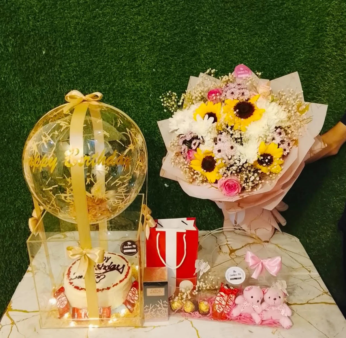 Luxury birthday combo with 2 lbs red velvet cake in acrylic box, custom balloon, floral handbag, mini teddy bears, chocolates and J. perfume for her
