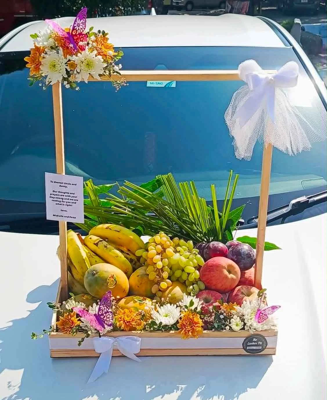 Elegantly wrapped luxury fruit basket with 6 to 8 kg mixed seasonal fruits and premium flower decoration for gift delivery in Pakistan.