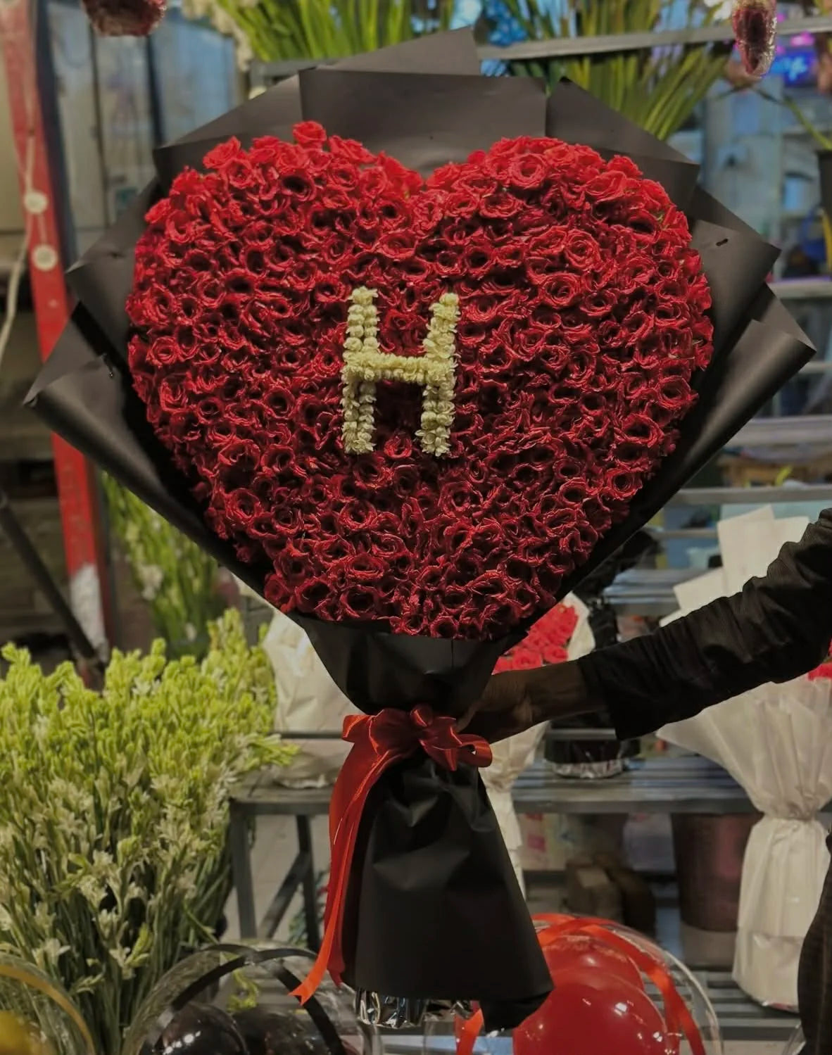 Oversized heart shaped red rose bouquet with white flower letter design