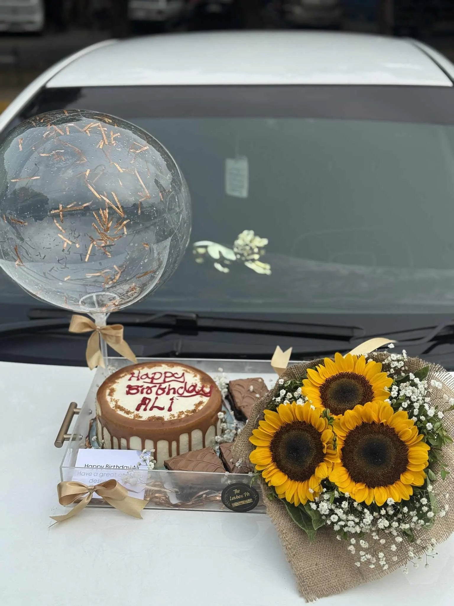 Luxury acrylic tray with lotus cake, sunflower bouquet, and brownies, premium birthday gift available in Islamabad and across Pakistan