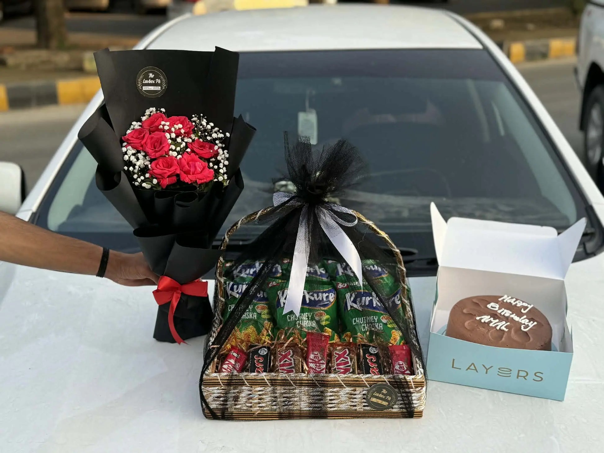 Mini flower bouquet with cake and snack basket arranged for gift delivery in Islamabad.