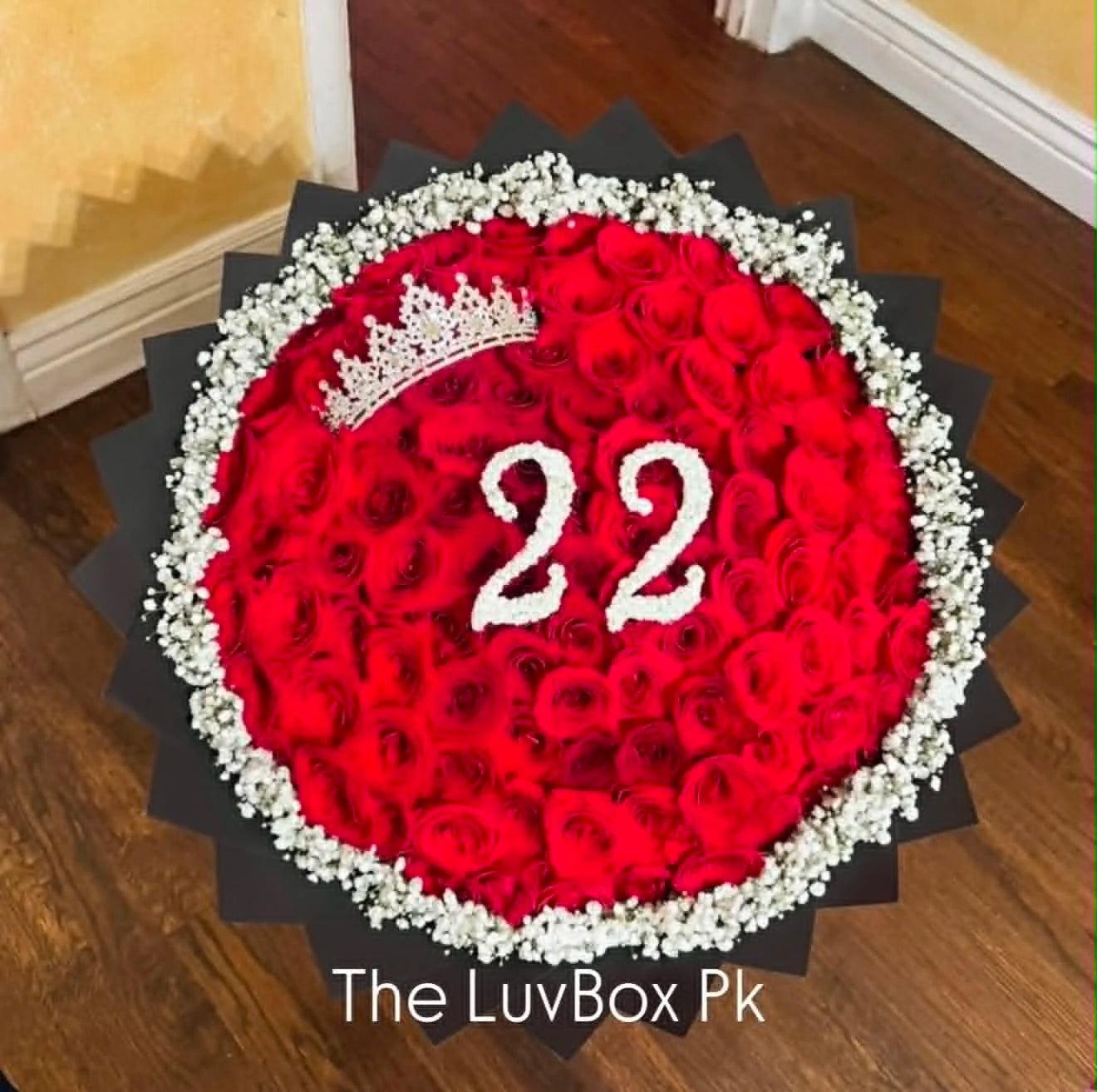 Luxury bouquet of 100 red roses with a queen’s crown embedded in the arrangement and a personalized age number made from white Baby’s Breath for her birthday.