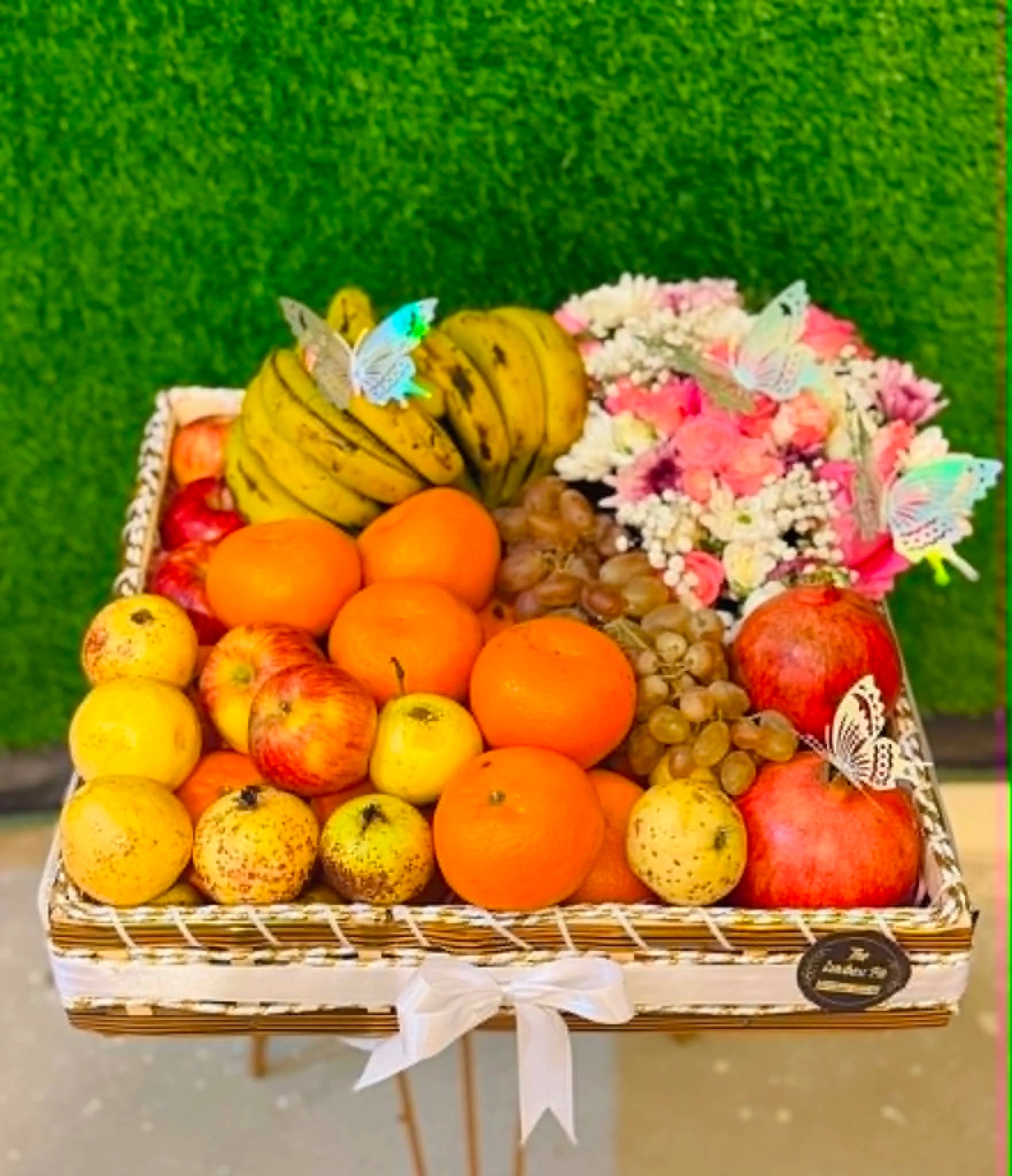 Ultra luxury fruit tray with 5 to 8 kg mixed seasonal fruits and premium mixed flowers, perfect for elegant gift delivery in Pakistan.