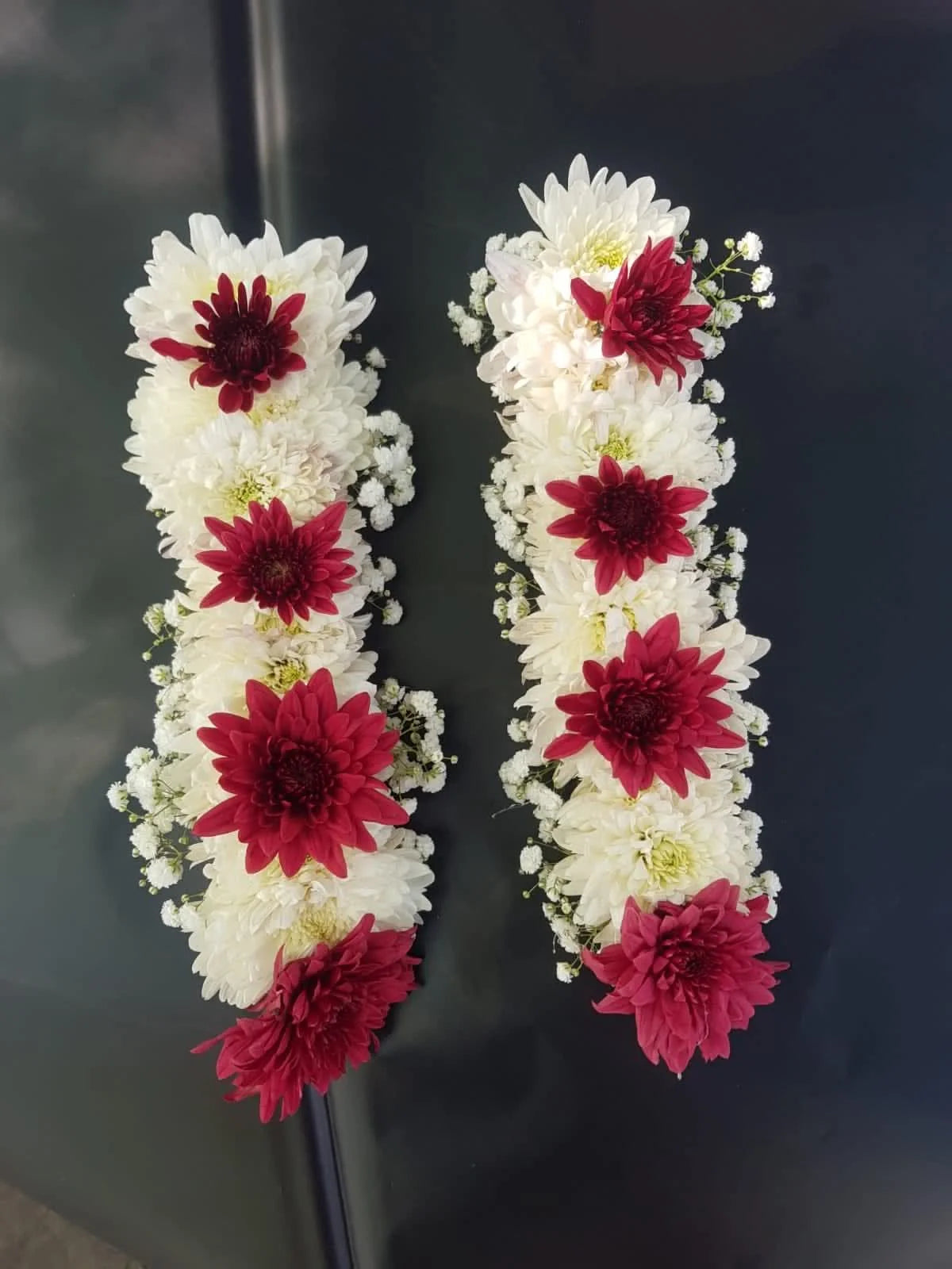 Beautiful wedding gajra pair made with white and maroon chrysanthemums, elegant bridal floral accessories for Mehndi, Nikah, and weddings in Pakistan.