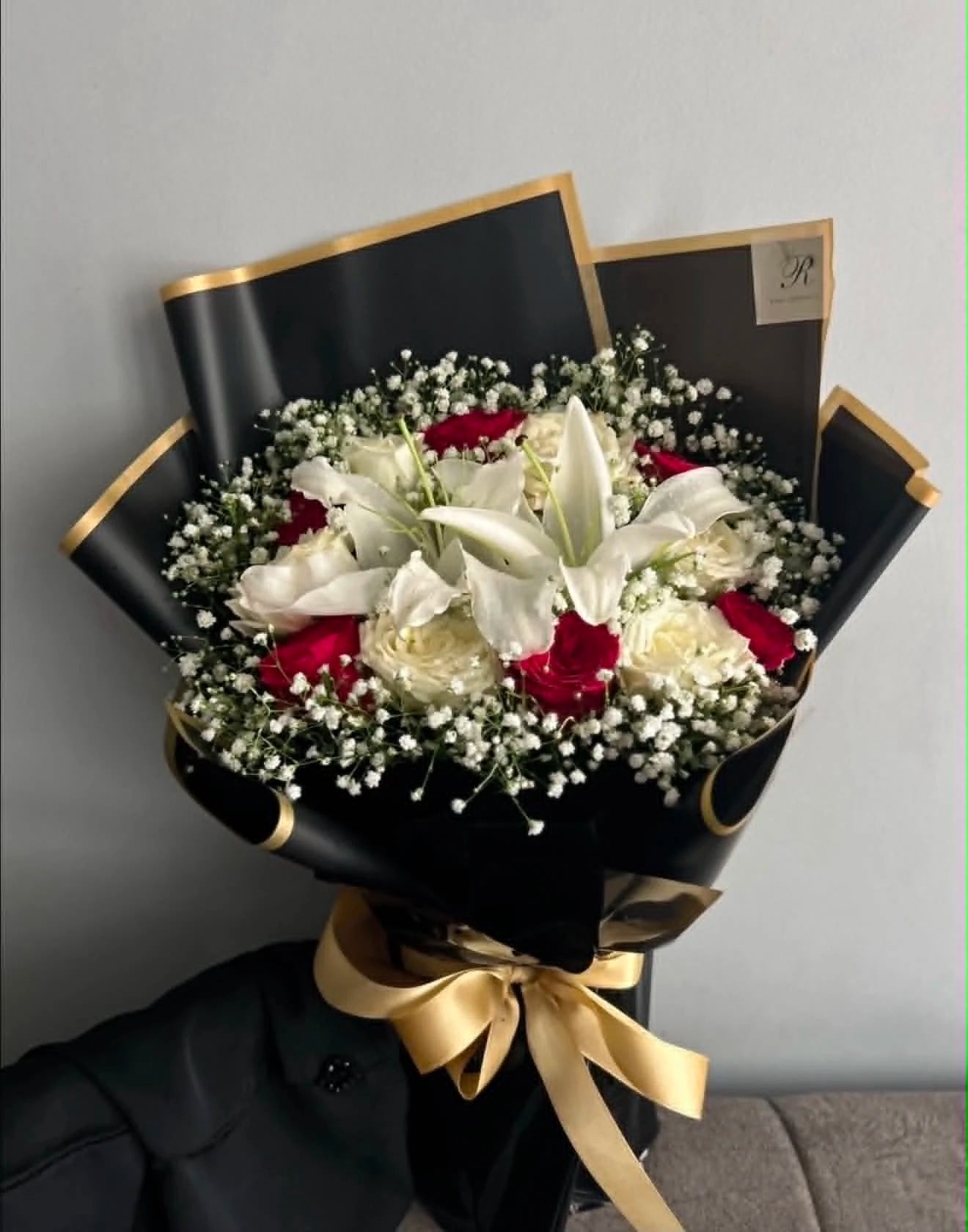 Cute flower bouquet featuring red roses, white roses and fresh lilies, beautifully arranged and wrapped for flower delivery in Islamabad.