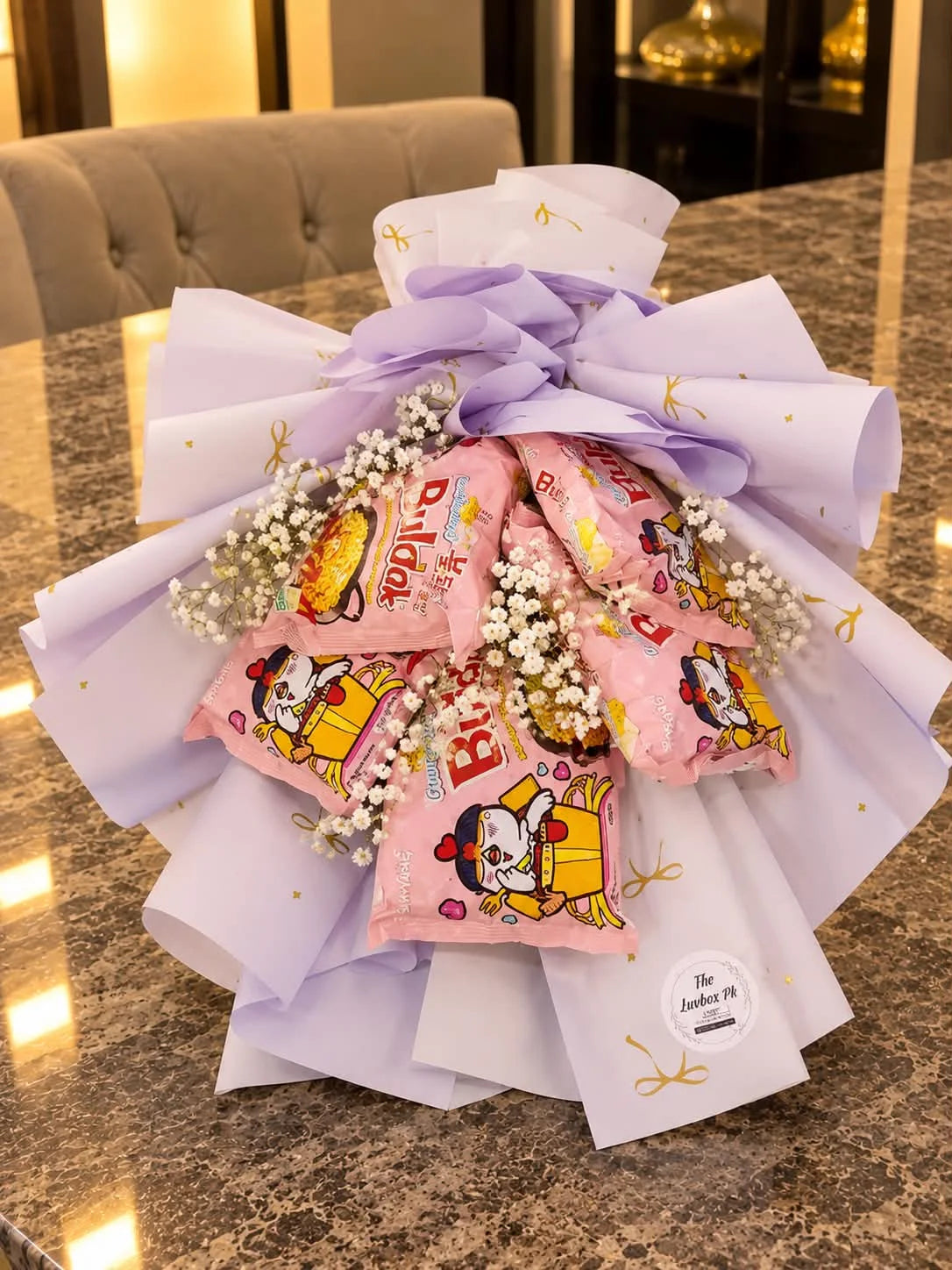 Trendy bouquet of six Buldak Korean spicy noodle packs with baby's breath flowers and aesthetic purple wrapping in Pakistan