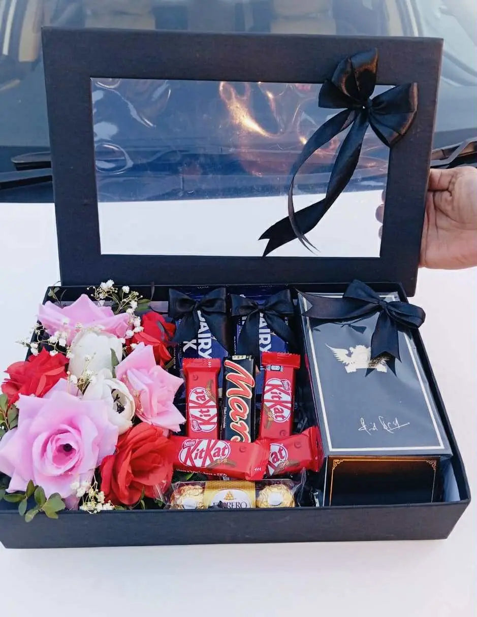 Black gift box with perfume, chocolates, and flowers – perfect gift for any occasion