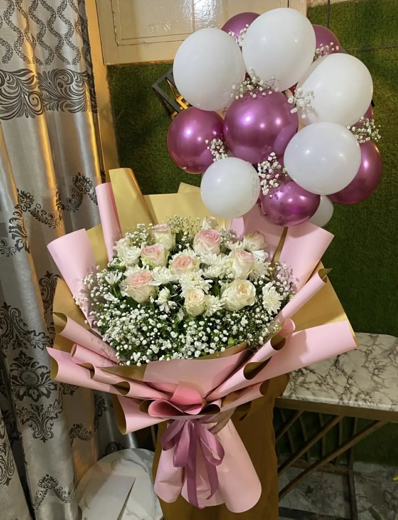 Oversized bouquet of white roses and chrysanthemums with balloon bunch on top for luxury gifting.