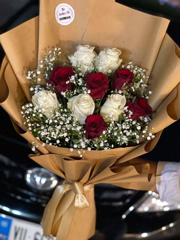 Elegant red and white rose bouquet in brown wrap – The LuvBox Pk, flower delivery in Islamabad.