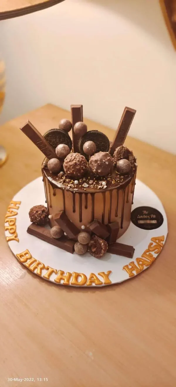 Luxury chocolate cake topped with KitKat, Dairy Milk, and Ferrero – best chocolate cake in Islamabad by The LuvBox Pk.