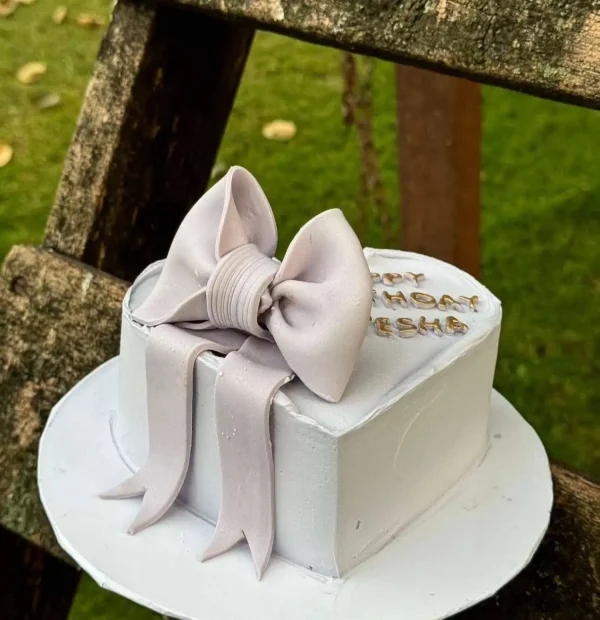 Purple heart-shaped cake with fondant bow – customized birthday cake for her in Islamabad.